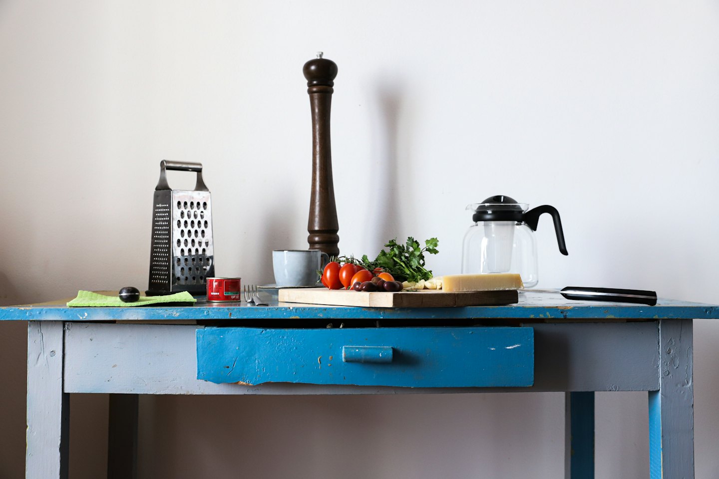 Cooking ingredients and kitchen tools arranged on a wooden table.